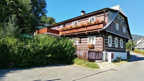 a house with a balcony with flowers on it at Chalupa pod Lysou in Rokytnice nad Jizerou