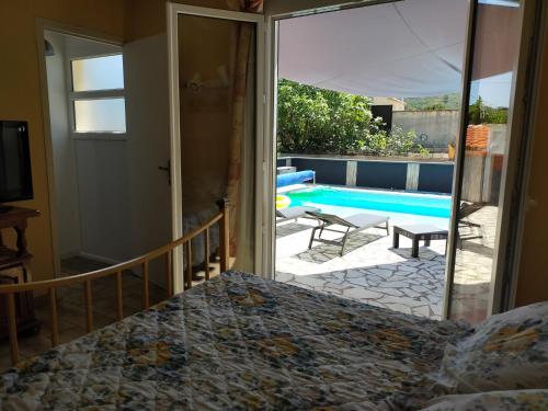 1 dormitorio con vistas a la piscina en Gîte climatisé L'OISELLERIE en Castelnou