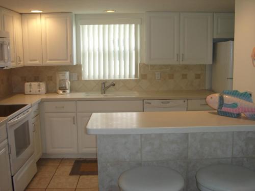eine Küche mit weißen Schränken und einer Arbeitsplatte in der Unterkunft Island House Beach Resort 23 in Point O'Rocks