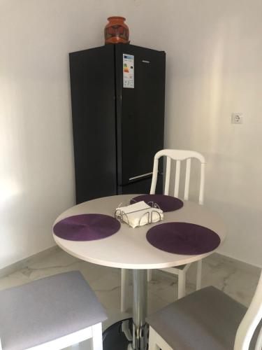 a white table with a black refrigerator and a purse on it at Tudor Apartment in Brăila