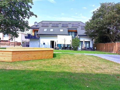 a house with a wooden fence in front of a yard at Gasthaus am Henriettenhof in Grömitz