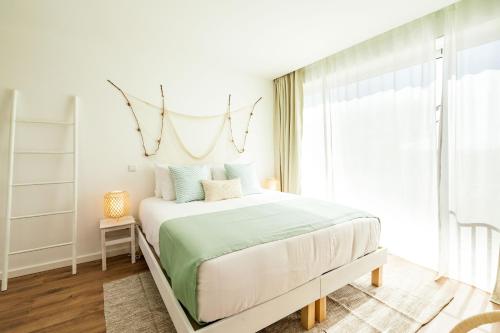 a bedroom with a bed and a window at Casa Vica - Sagres Apartments in Sagres