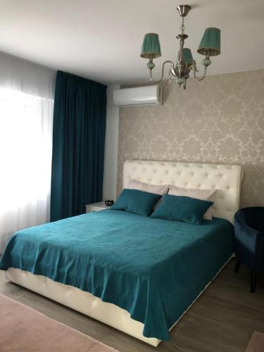 1 dormitorio con cama con sábanas azules y ventana en Tudor Apartment, en Brăila