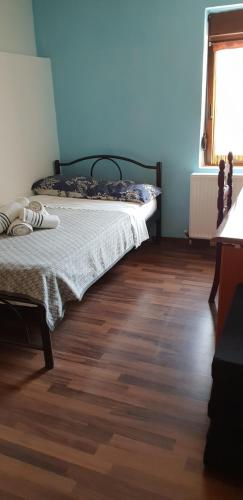 a bedroom with a bed and a wooden floor at Mavridis House in Eleftheroúpolis