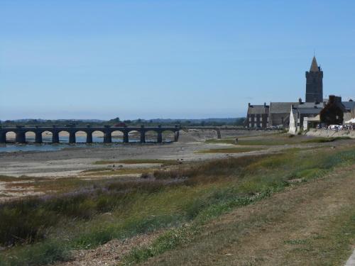 a bridge over a body of water with a building at Maison centre bourg Port-Bail in Portbail