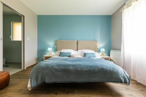 1 dormitorio con 1 cama grande y paredes azules en Les prairies du Mont -La vallée Saint Pierre, en Sougéal