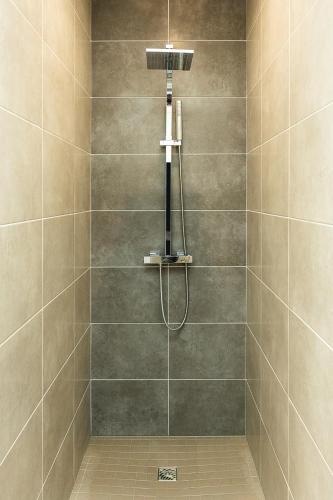 une douche avec pommeau de douche dans une salle de bain dans l'établissement Les prairies du Mont -La vallée Saint Pierre, à Sougéal