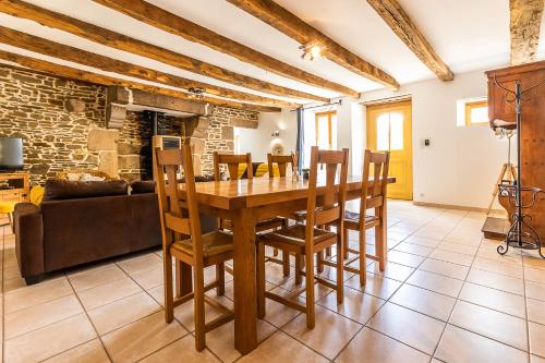 Il dispose d'une cuisine et d'un salon avec une table et des chaises en bois. dans l'établissement Les prairies du Mont - Le gite de La Chapelle, à Sougéal