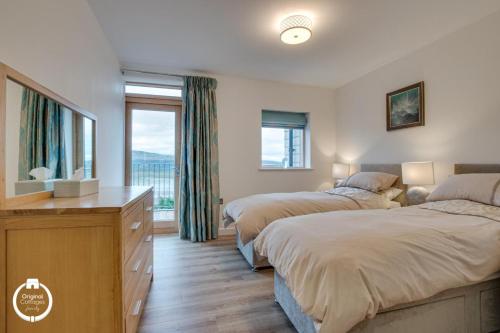 sypialnia z 2 łóżkami i dużym oknem w obiekcie The Old Stables Aberdyfi apartment 3 w mieście Aberdyfi
