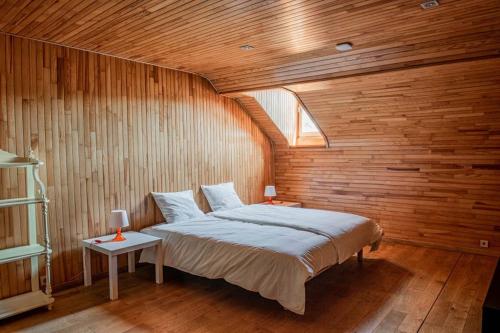 1 dormitorio con 1 cama grande en una pared de madera en Les Hauts de Meuse en Profondeville