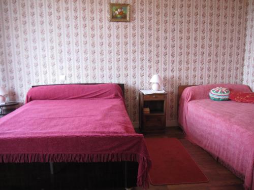 een slaapkamer met 2 bedden met roze lakens en een tafel bij LA FAURIE in Brantome en Perigord