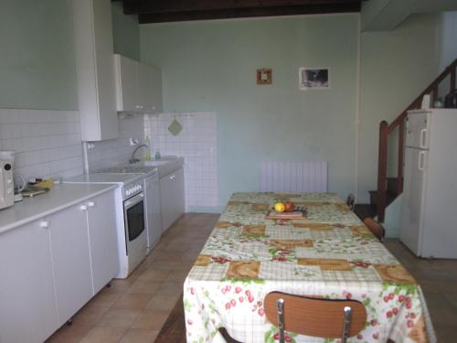 une cuisine avec une table recouverte d'une nappe dans l'établissement LA FAURIE, à Bourdeilles