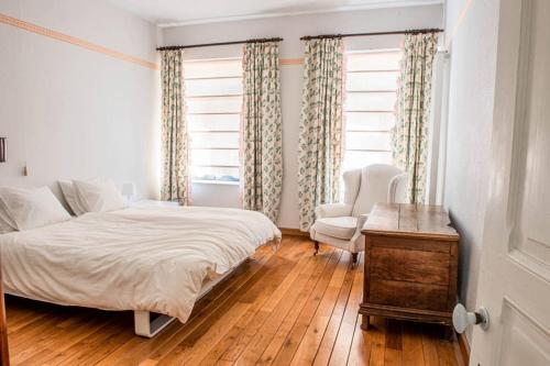 a bedroom with a bed and a chair and a window at Les Hauts de Meuse in Profondeville