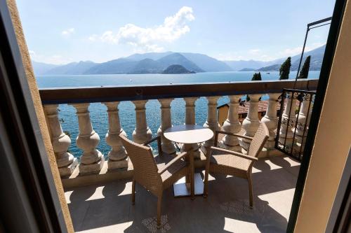 
a patio area with chairs, tables and a boat at Hotel Royal Victoria, by R Collection Hotels in Varenna
