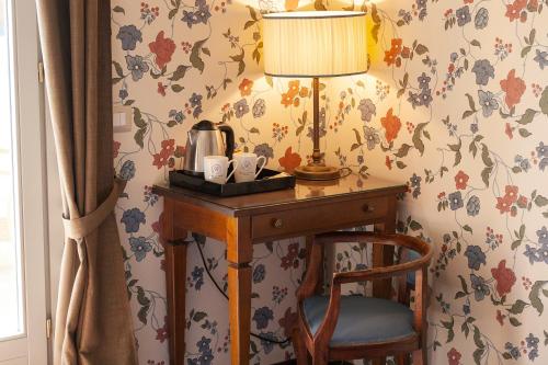
a wooden table topped with a lamp next to a window at Hotel Royal Victoria, by R Collection Hotels in Varenna

