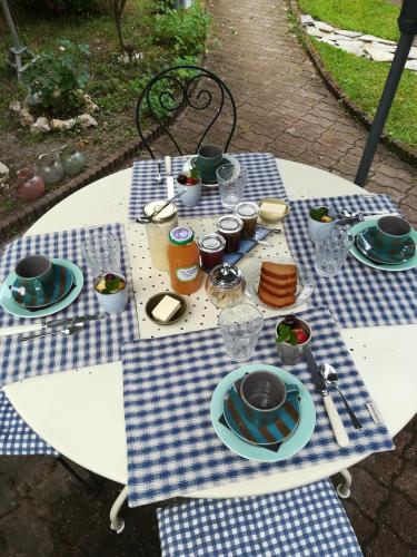 une table de pique-nique avec une nappe à carreaux bleus et blancs dans l'établissement Lait & Lit, à Triqueville