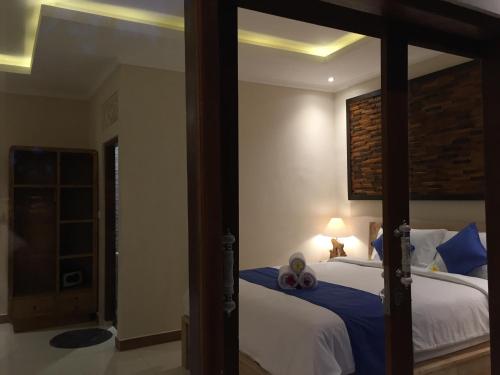 a bedroom with a large bed with a large mirror at Cahaya Guest House in Ubud