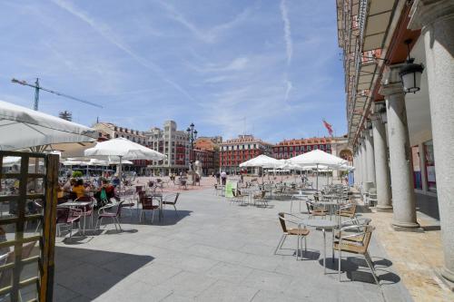d'une terrasse avec des tables, des chaises et des parasols blancs. dans l'établissement Plaza Mayor Centro - Familiar-Sin Ruido-Wifi-Ascensor, à Valladolid