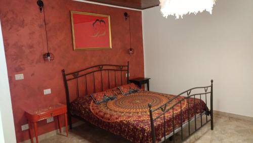a bedroom with a bed and a red wall at La casa sul tetto, Room's & Glamping in Recanati
