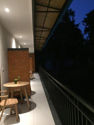a balcony with a table and chairs on it at Cahaya Guest House in Ubud