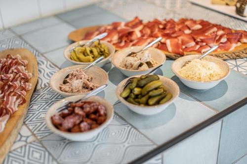 a buffet with bowls of different types of food at Hotel Parks in Velden am Wörthersee