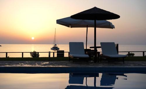 two chairs and an umbrella next to a pool at Kyparissia Blue Boutique Hotel in Kyparissia