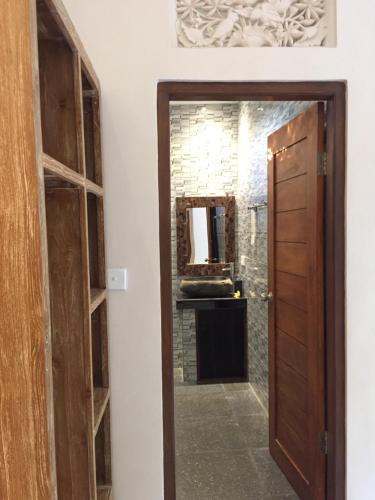 a door leading into a bathroom with a mirror at Cahaya Guest House in Ubud