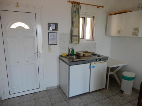 a kitchen with a sink and a white door at Villa Teozenia in Achladies