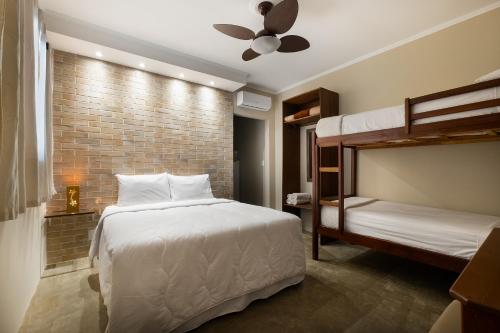 a bedroom with two bunk beds and a brick wall at Chalés Santa Catarina in Socorro