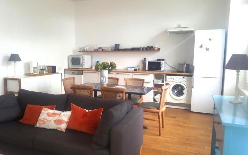 un salon avec un canapé et une cuisine dans l'établissement Appartement spacieux à 200 m de la plage - Hôtel de l'Europe, à Perros-Guirec