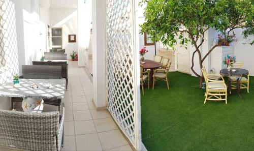 een kamer met een groene vloer en tafels en stoelen bij Zia Mia B&b in Olbia