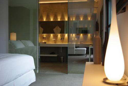a bedroom with a bed and a bathroom with a mirror at Bdesign & Spa in Paradou