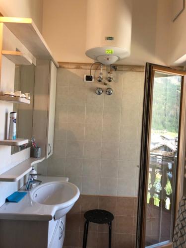 La salle de bains est pourvue d'un lavabo et d'un miroir. dans l'établissement Appartamento Primiero San Martino di Castrozza, à Fiera di Primiero