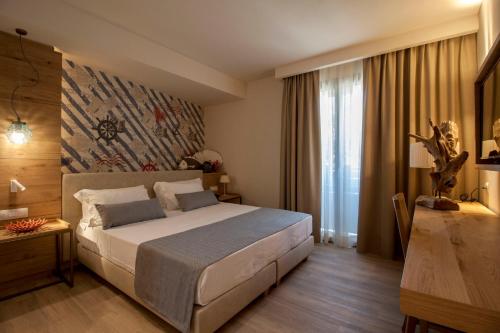 a bedroom with a large bed and a large window at Aqua Boutique Hotel in Castiglione della Pescaia