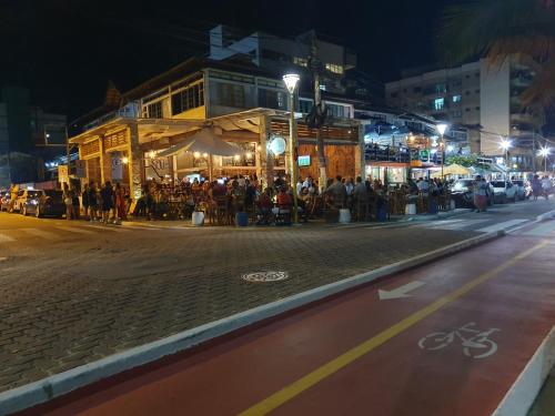 a group of people standing on a street at night at Pousada Solar dos Cavaleiros Mendes in Macaé