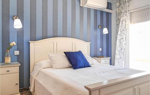 1 dormitorio con 1 cama con rayas azules y blancas en Stunning Apartment In Tossa De Mar With Kitchen, en Tossa de Mar