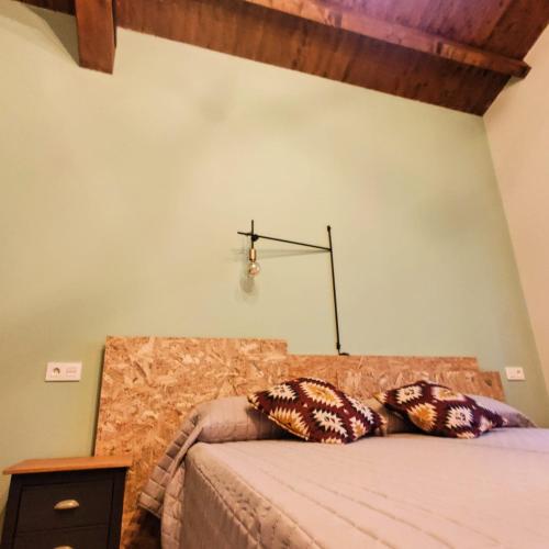 a bedroom with a bed with two pillows on it at Casa Rural Vereda - Fábrica de Cerveza in Ledigos