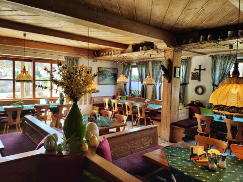 キプフェンベルクにあるLandhotel zum Rabenの木製の天井、テーブルと椅子のあるレストラン