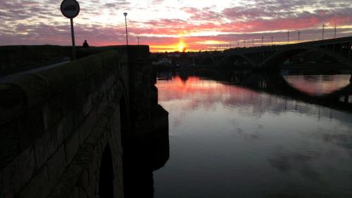 a bridge over a river with the sunset in the background at YHA Berwick in Berwick-Upon-Tweed