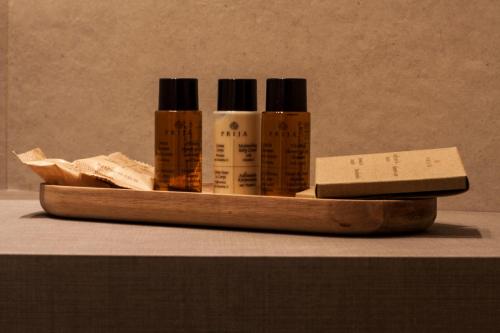 a wooden tray with four bottles of essential oils at Aqua Boutique Hotel in Castiglione della Pescaia