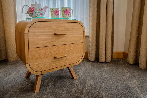 a wooden dresser with two vases on top of it at Bariseele B&B in Bruges