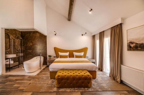 a bedroom with a large bed and a tub and a bath room at The Berg's 1 in Ocna-Mureşului