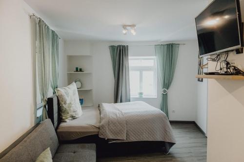 um quarto com uma cama, um sofá e uma janela em Stadt Land Fluss first Apartments by Zollhaus em Forchheim