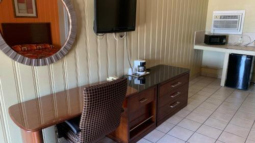 a hotel room with a desk and a mirror at Budget Inn Greenville in Greenville