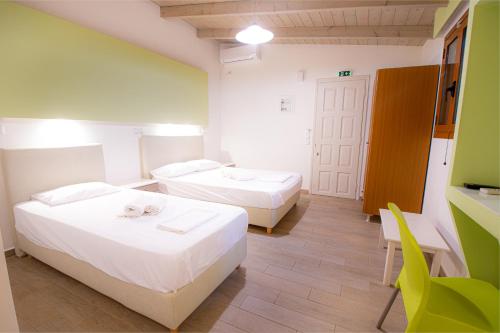 a room with two beds and a chair in it at Apartments Korakakis Beach in Finikounta
