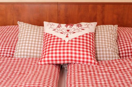 two pillows on a bed with a red and white pillow at Löwenbräu am Kohlmarkt in Wernigerode