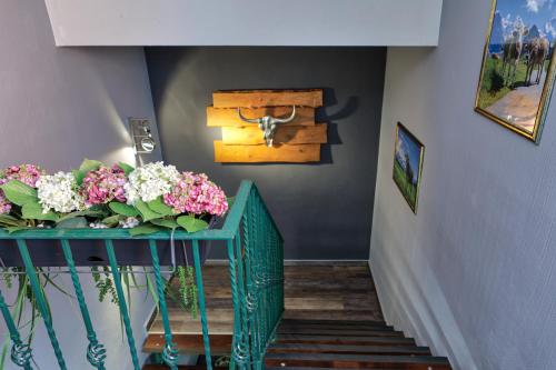 a staircase with a green railing with flowers on it at Löwenbräu am Kohlmarkt in Wernigerode