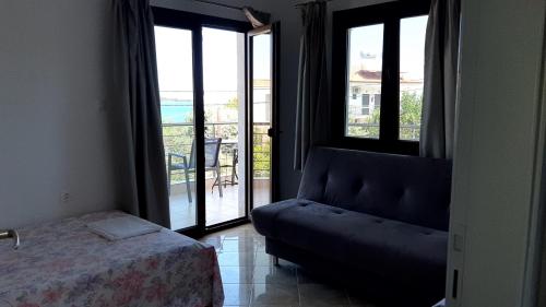 a bedroom with a couch and a view of a balcony at House Anna Houhlia in Vourvourou