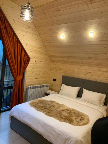 a bedroom with a large bed in a wooden room at Eco Chalet Tsaghkadzor in Tsaghkadzor