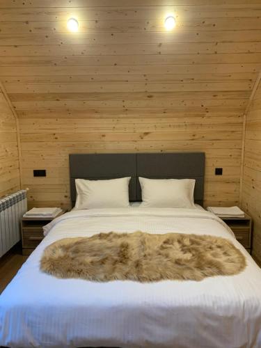 a bed with a furry blanket on top of it at Eco Chalet Tsaghkadzor in Tsaghkadzor